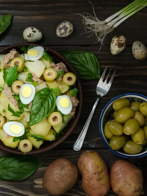 spanish tuna salad next to potatoes, olives and quail eggs
