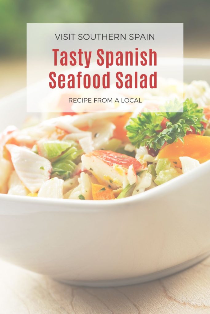 spanish seafood recipe in a white bow. On top it's written tasty spanish seafood salad. 