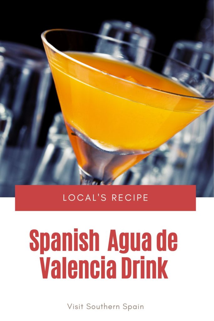 closeup with an agua de valencia glass. Under it's written Spanish agua de valencia drink. 