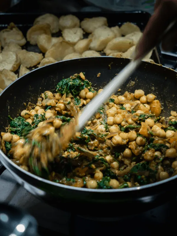 Espinacas con Garbanzos being made in a pan. 20 Best Spanish Vegetarian Tapas You Will Love