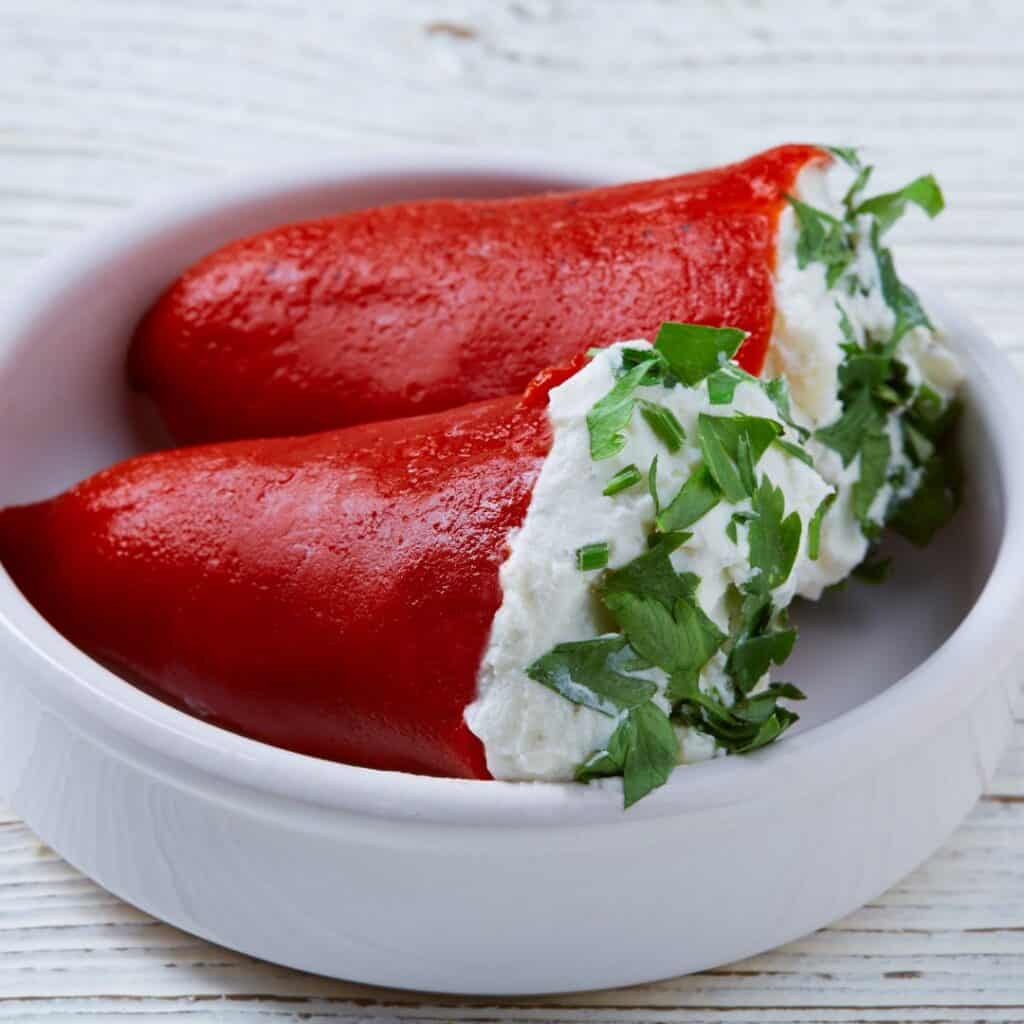 red peppers stuffed with cheese and herbs in a white bowl