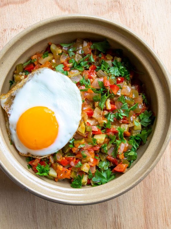 Pisto manchego in a bowl with a sunny side egg on top. 20 Best Spanish Vegetarian Tapas You Will Love