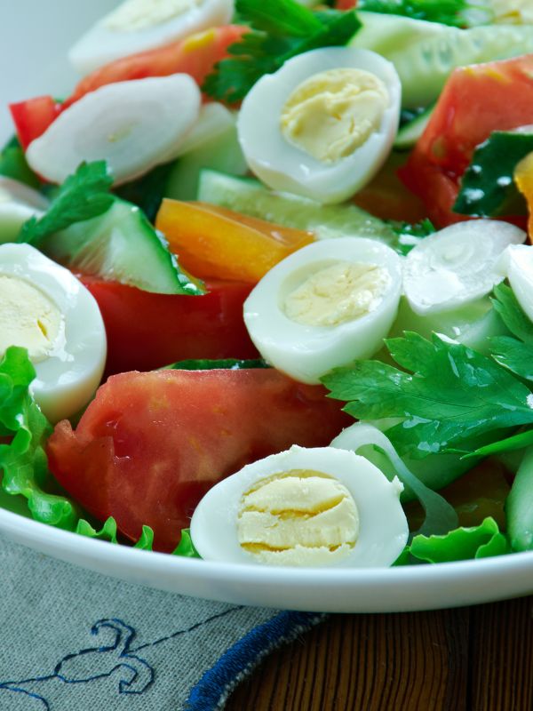 closeup with spanish green salad with eggs, lettuce and tomatoes