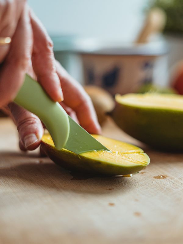 cook cutting a mango for the ensalada de mango