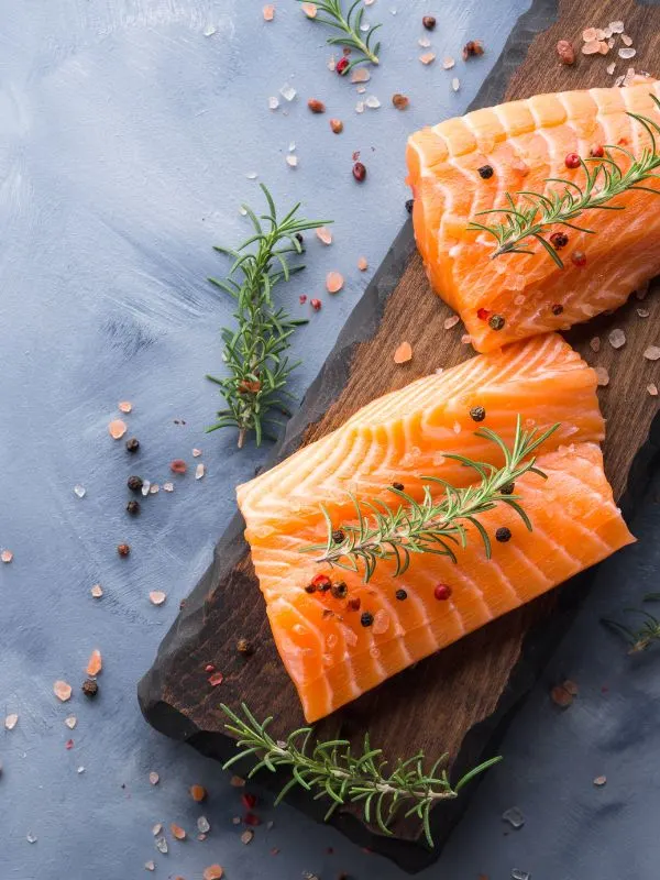 fresh salmon pieces on a wooden board for the spanish salmon recipe