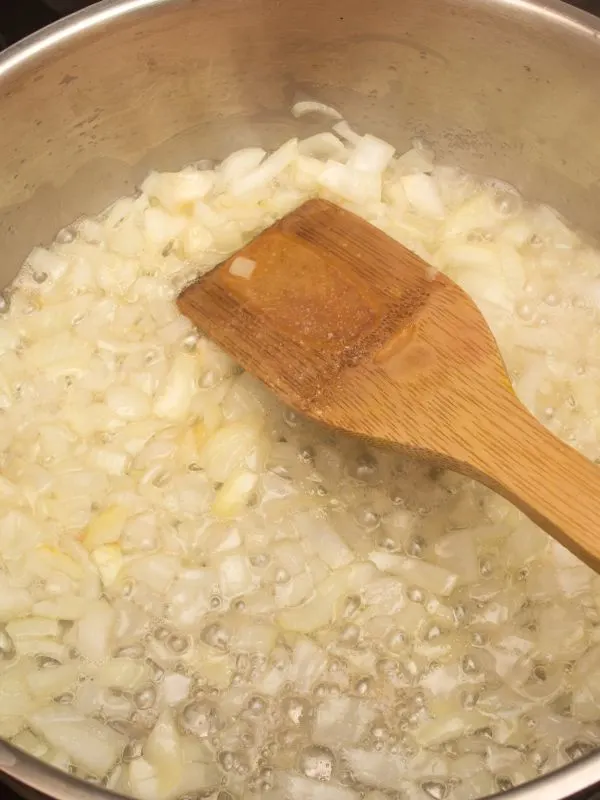 frying onion in a pan for the spanish beans and tomatoes.