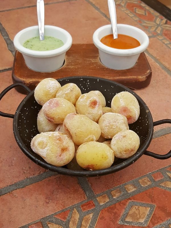 papas arrugadas recipe in a pot served with 2 types of sauces.