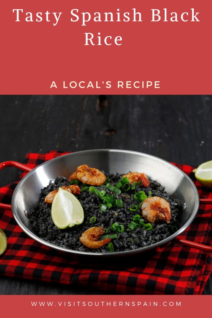 arroz negro in a paella pan on a kitchen table. On top it#s written tasty spanish black rice.