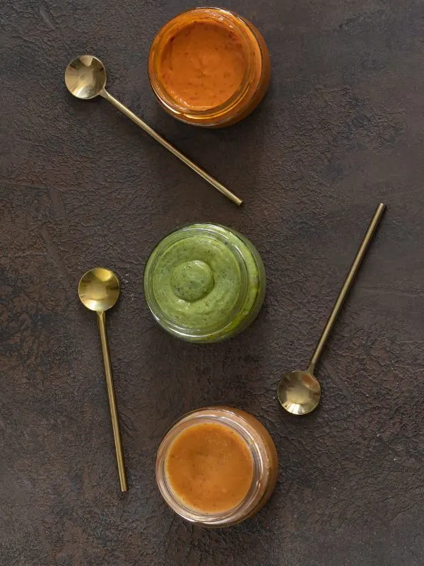 3 types of spanish mojo sauce on a black surface.