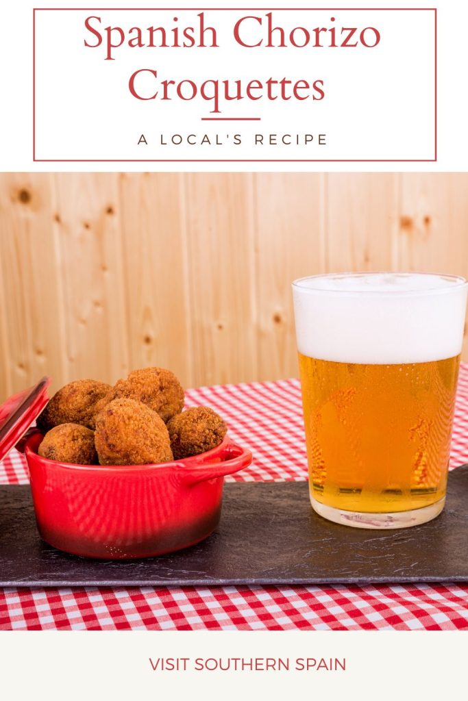 spanish croquettes in a red bowl with a glass of beer next to it. On top it's written Spanish chorizo croquettes.