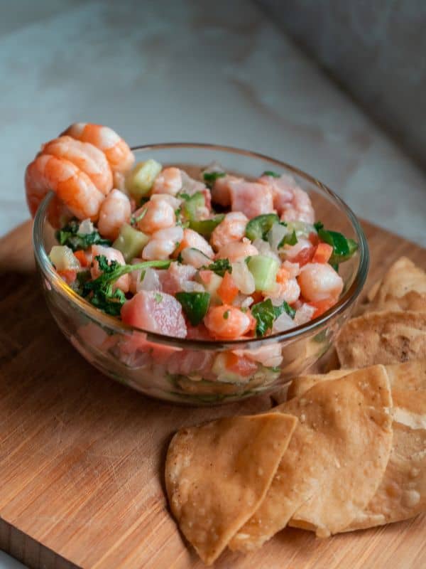 Spanish ceviche recipe with shrimp served on a wooden board with tortilla.