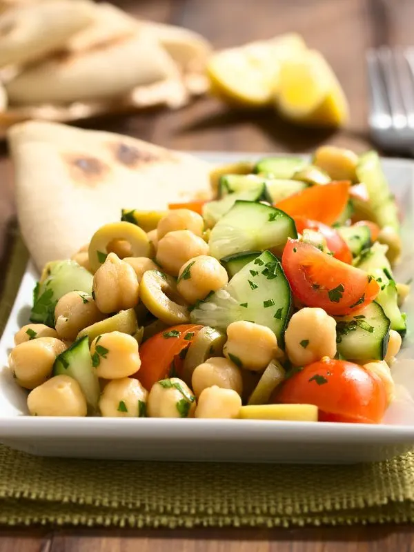a small bowl of spanish chickpea salad served with tortilla bread.