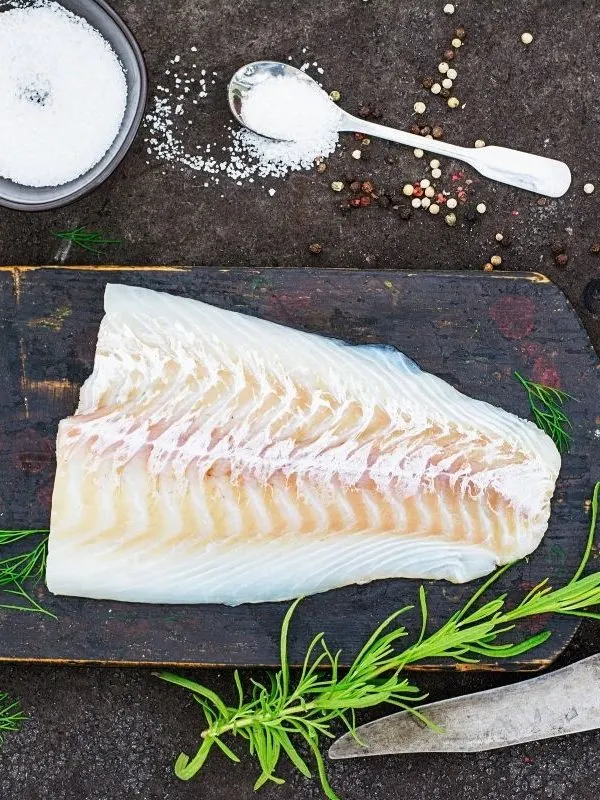 cod fillet on a black board for the traditional spanish salad recipe.