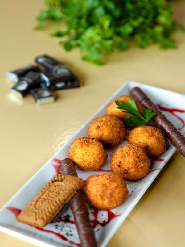 chocolate croquettes on white plate decorted with sweets