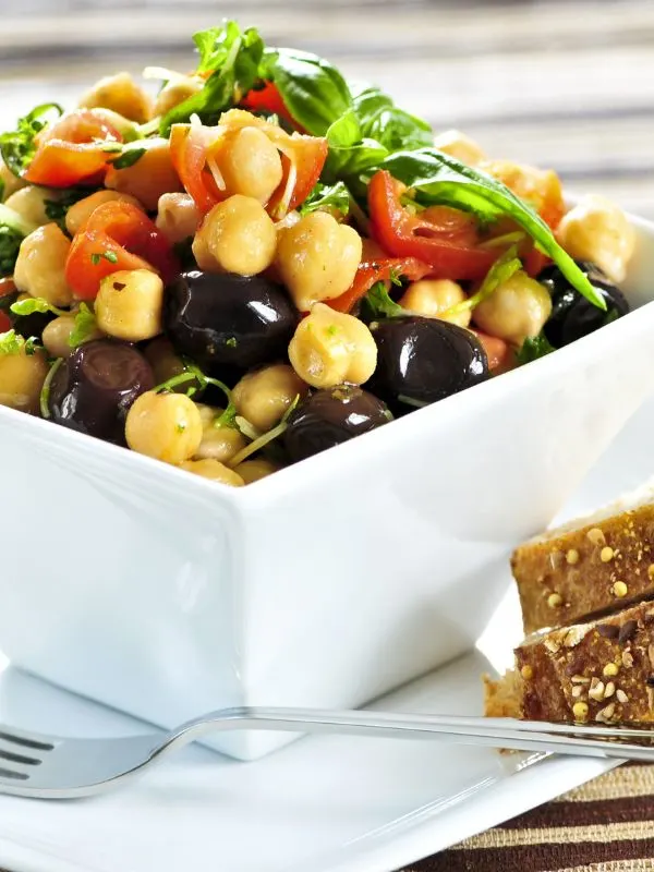 closeup with spanish chickpea salad in a white bowl.
