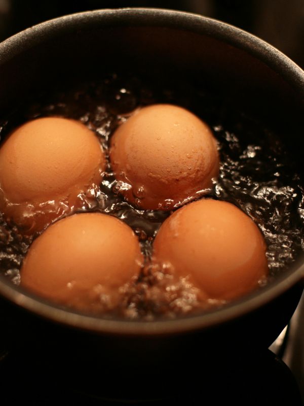 eggs boiling in a pot for the spanish macaroni salad.