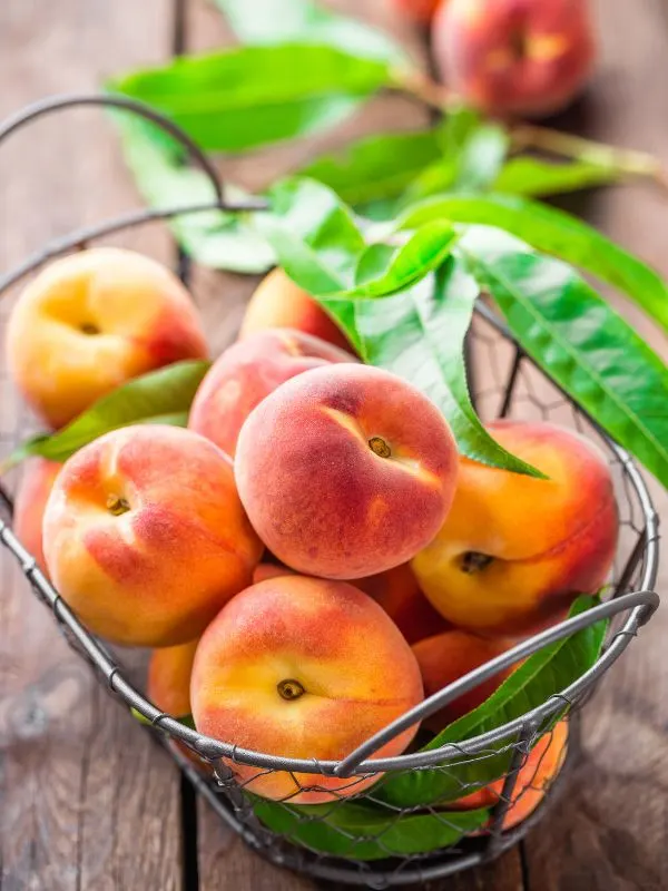 fresh peaches in a basket for the peach gazpacho.