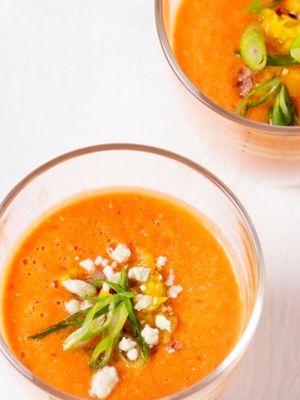 Cantaloupe Gazpacho in 2 bowl on a white surface.