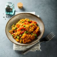 vegetable paella recipe in a bowl on a kitchen table.