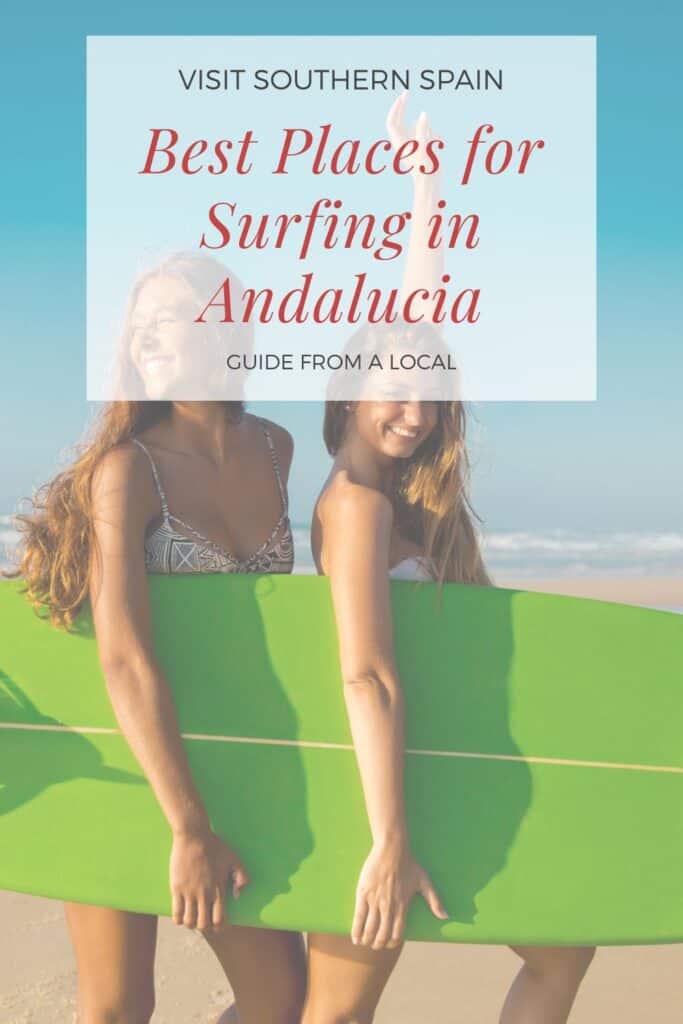 2 friends with a surf board while surfing in andalucia.