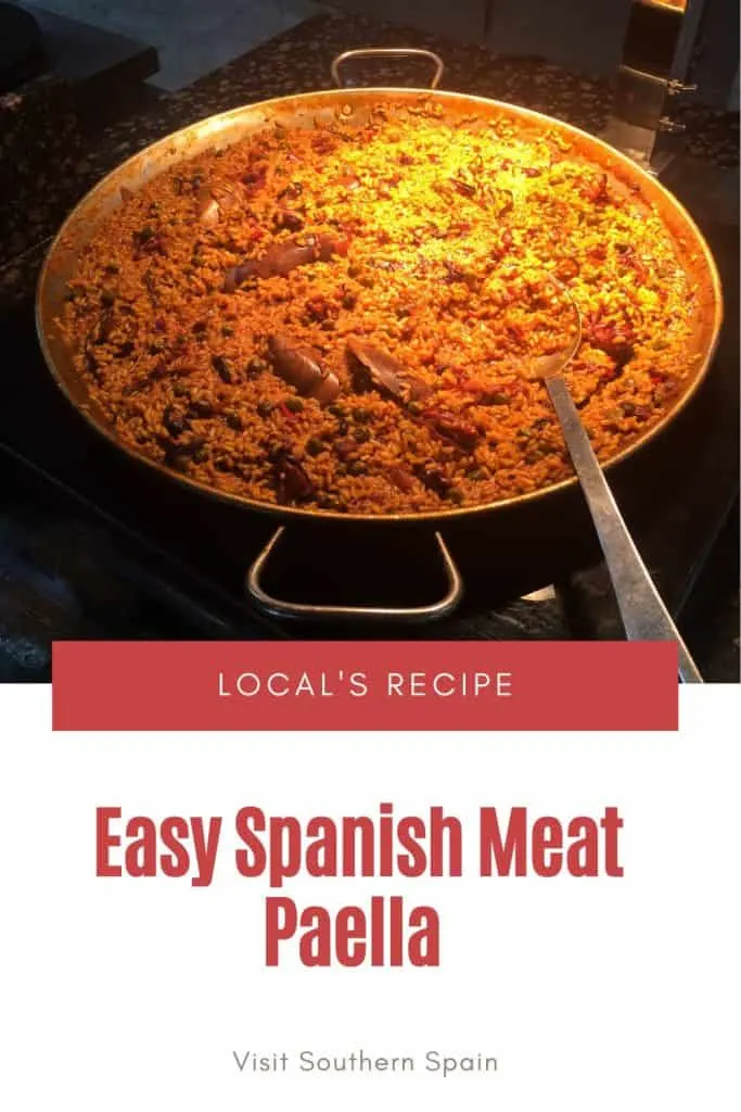 a pin with meat paella recipe being prepared on the stove.