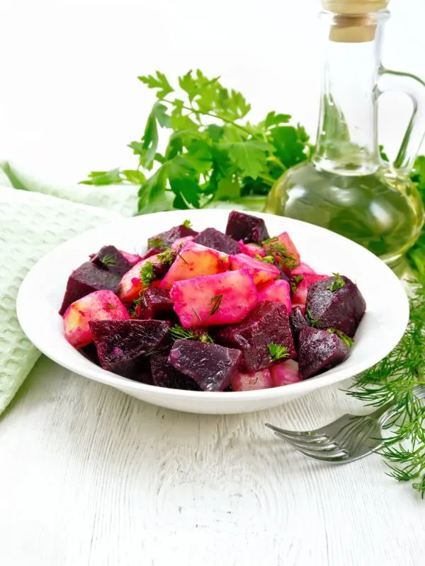 spanish potato and beet salad in a bowl with olive oil on the background.spanish potato and beet salad in a bowl with olive oil on the background.