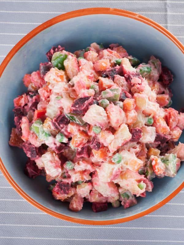 spanish potato salad with beets in a clay bowl.