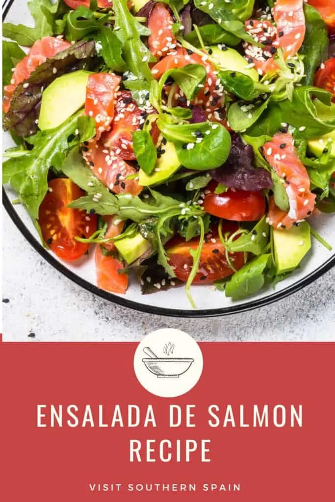 a pin with ensalada de salmon, salmon salad with avocado, tomatoes in a bowl.