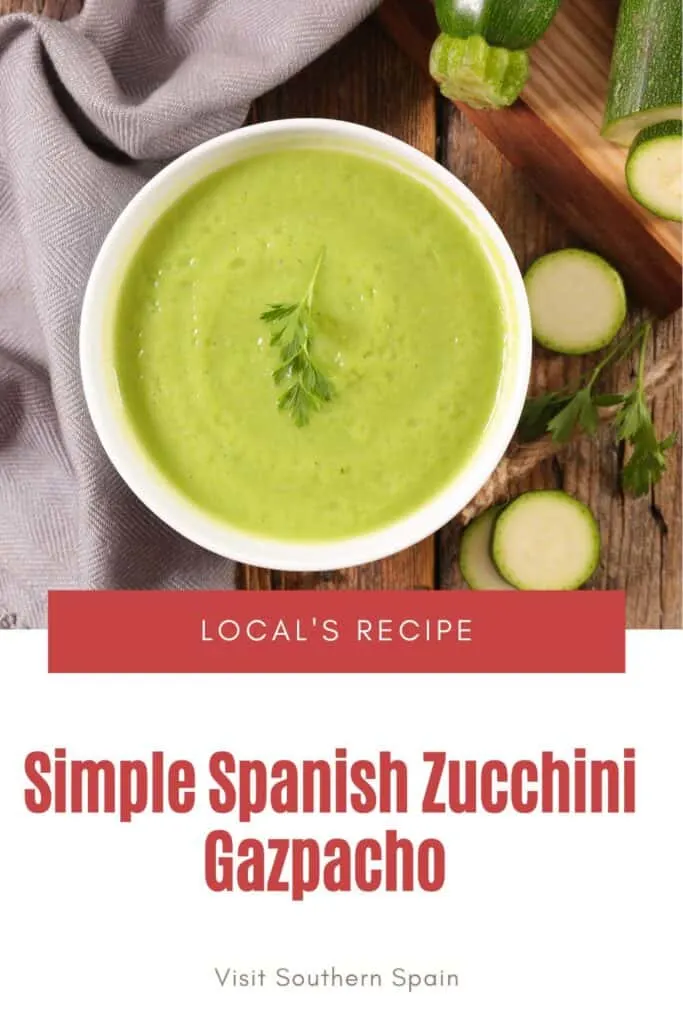 a pin with zucchini gazpacho in a bowl on a wooden table.