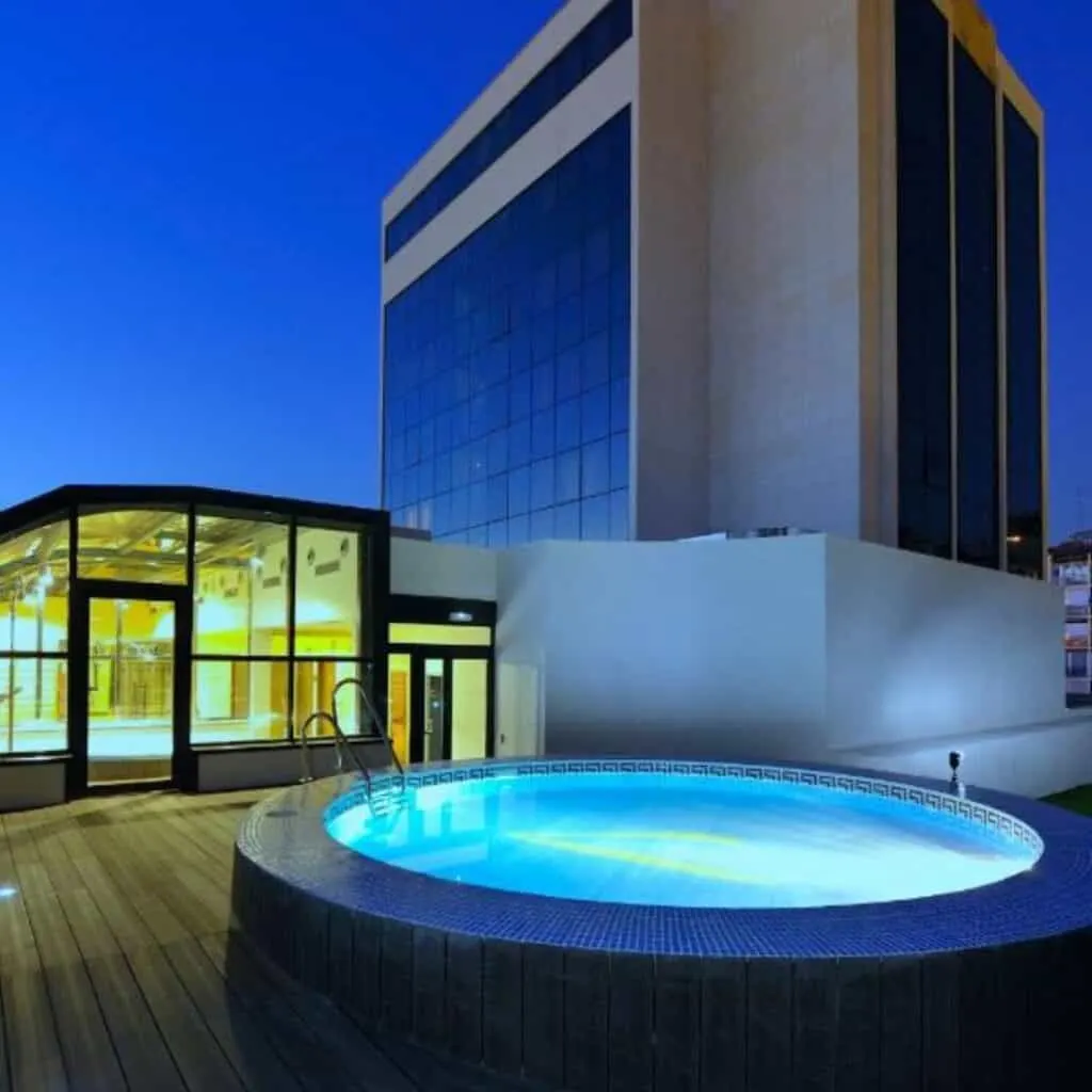 an outdoor pool in front of a building at night