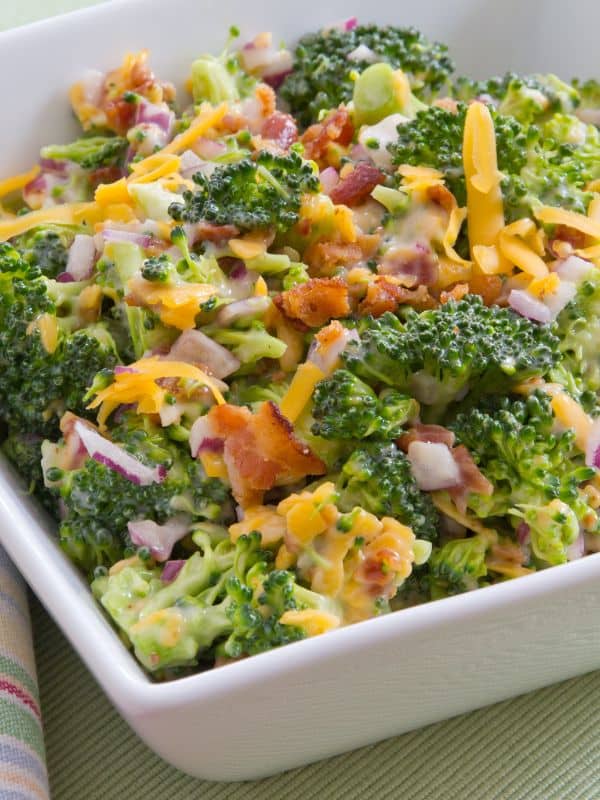 a bowl of ensalada de broccoli with cheese and onion
