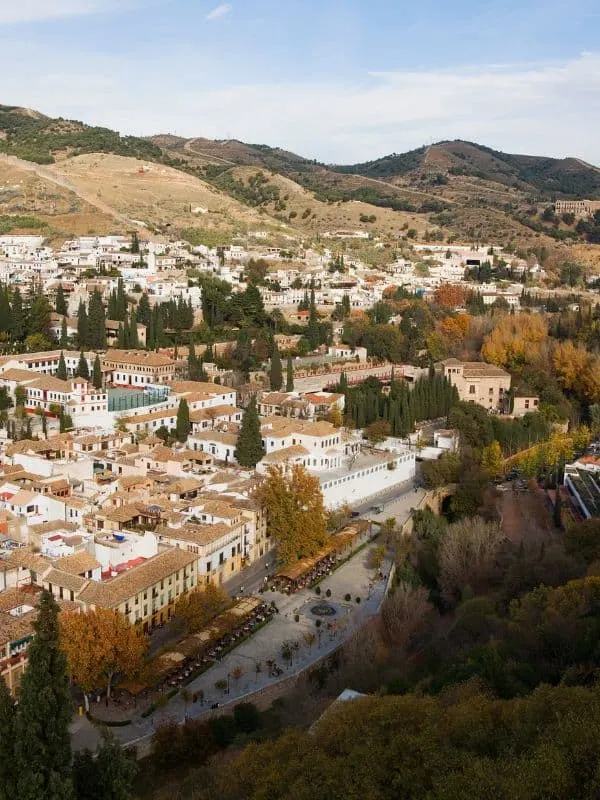 aerial view of the Sacromonte in Granada filled with white houses with mountain at the back