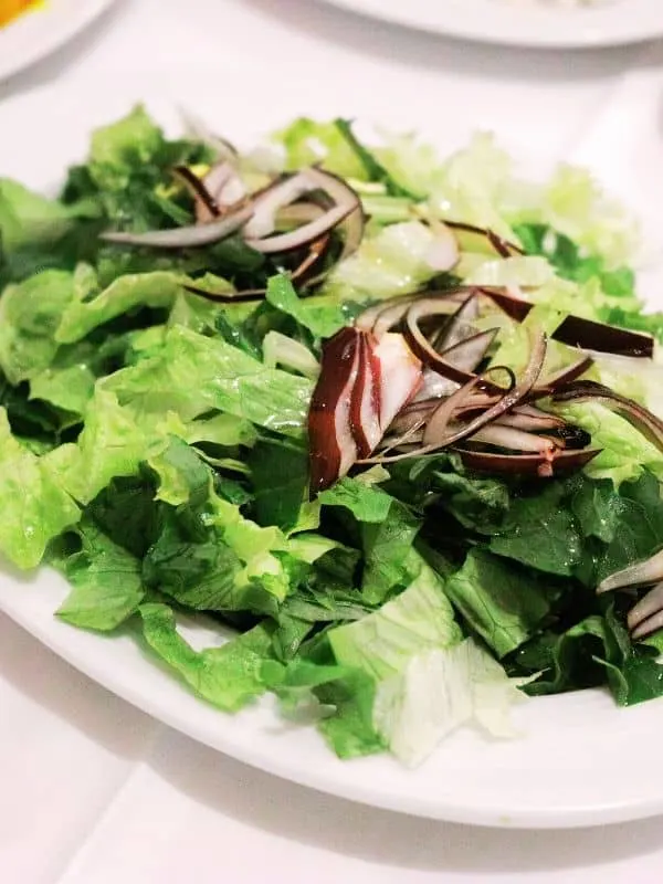 spanish green salad with onion on a plate
