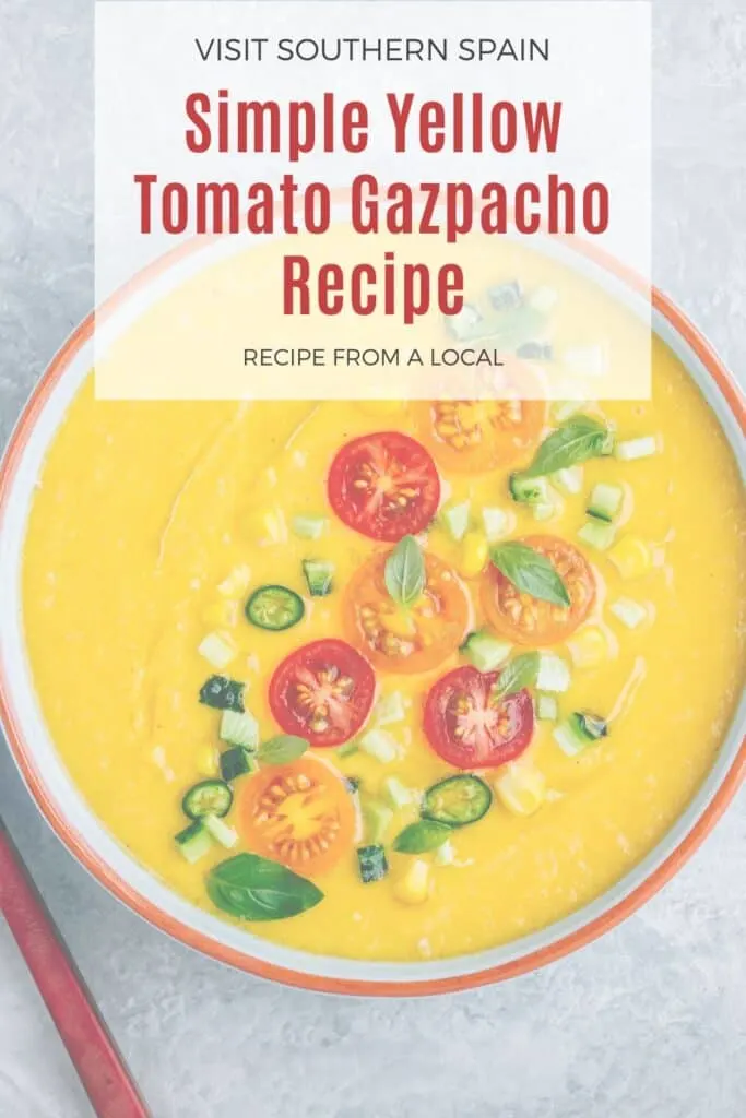 a pin with a closeup of a yellow tomato gazpacho decorated with fresh cherry tomatoes.