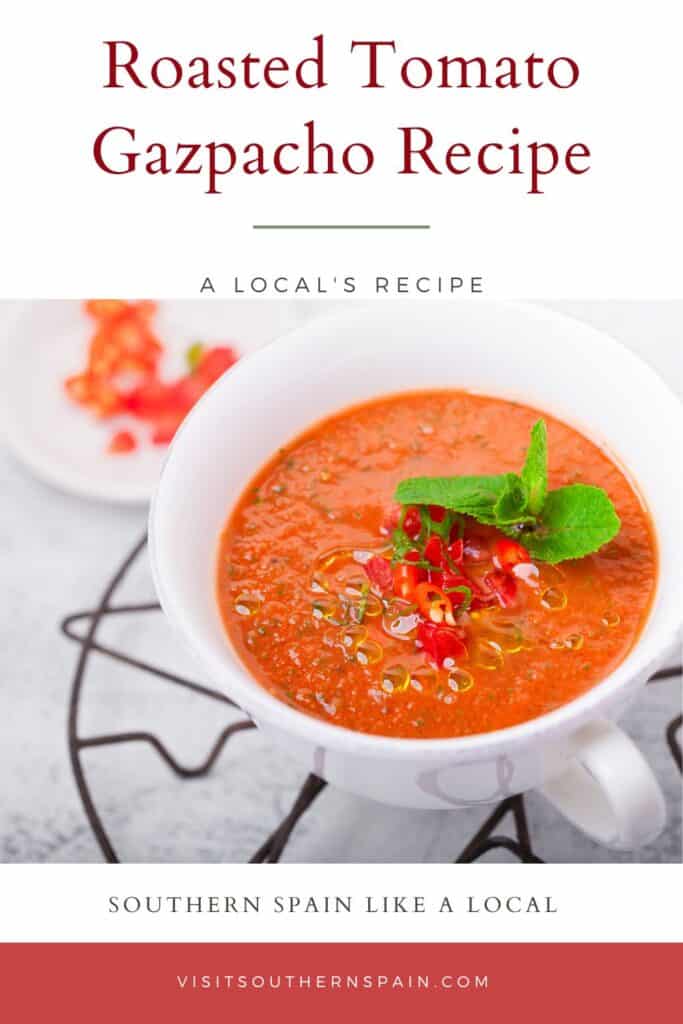 a pin with a bowl of roasted tomato gazpacho decorated with fresh vegetables.