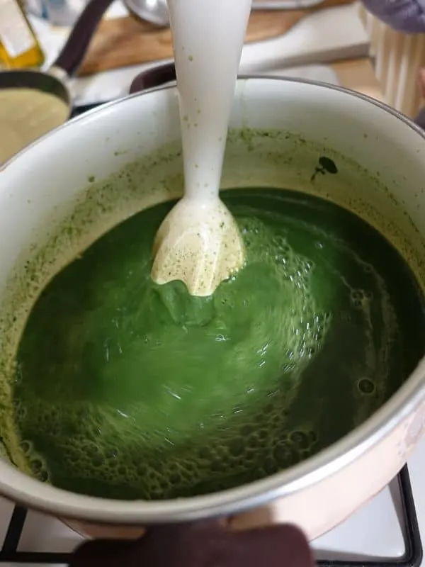 cold asparagus soup made with a hand mixer in a white pot