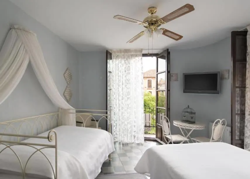 cozy room with 2 separate beds and TV at Pension Venecia Gomerez, Granada