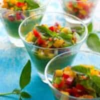 Green Tomato Avocado Gazpacho in glass bowls with fresh vegetables on top