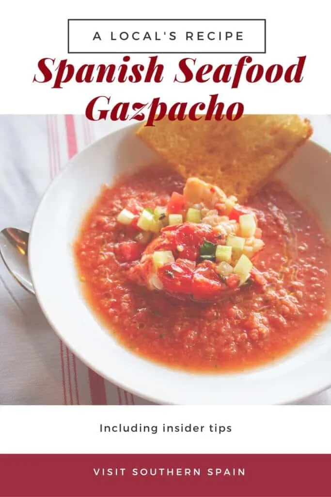 a pin with seafood gazpacho. on a plate served with bread.