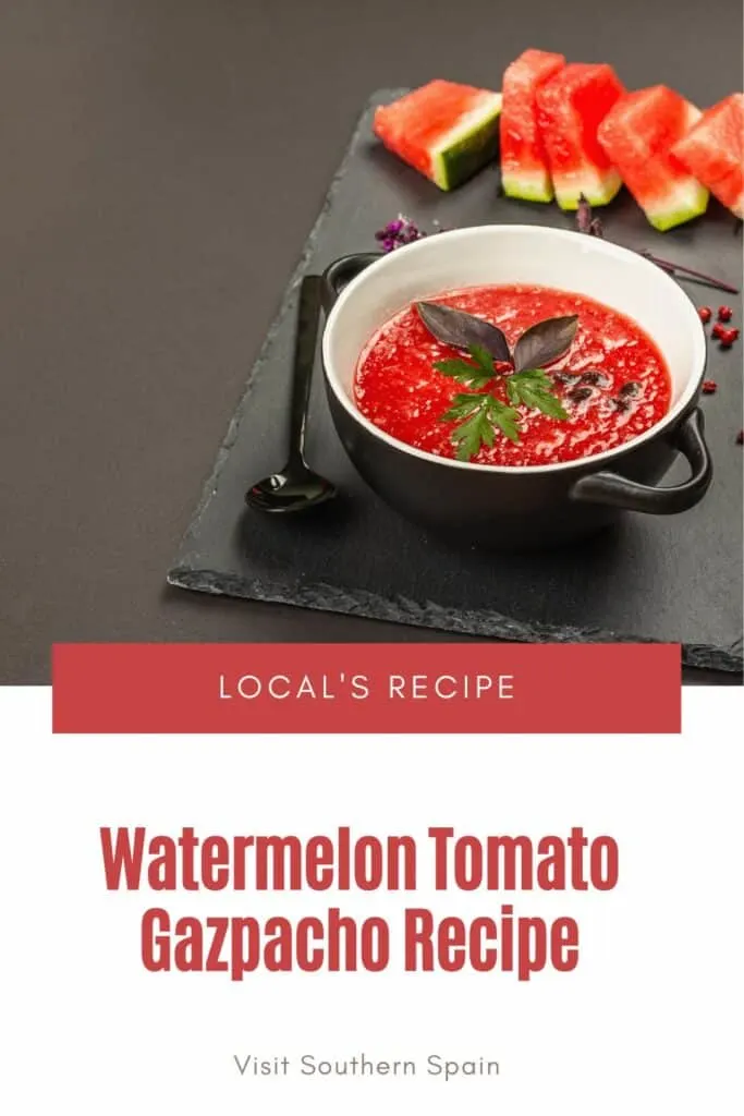 a pin with watermelon tomato gazpacho in a black bowl on a black board.