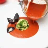 Avocado Tomato Soup in a white bowl, tomato gazpacho being poured from a jar