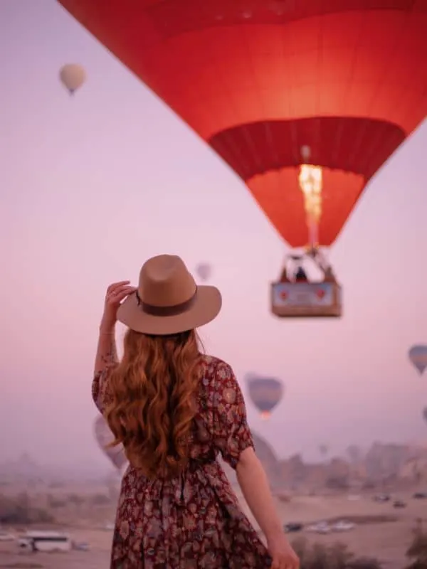 a girl watching a hot air balloon flying in Marbella