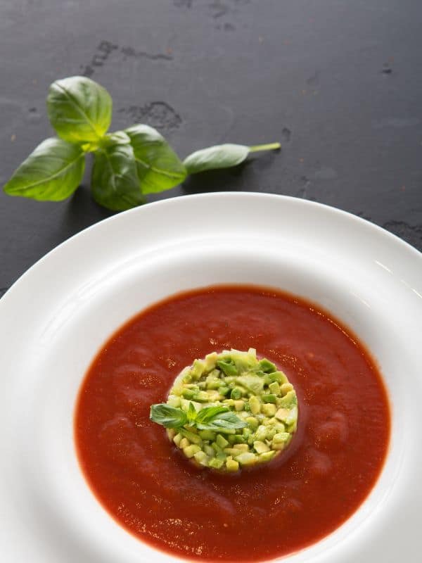 avocado tomato soup decorated with chopped avocados
