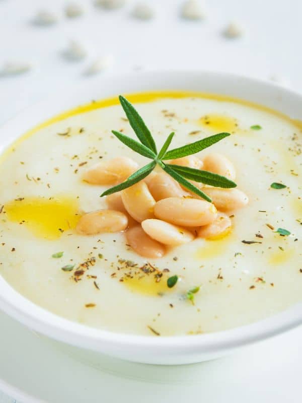 closeup of a white cold bean soup decorated with olive oil