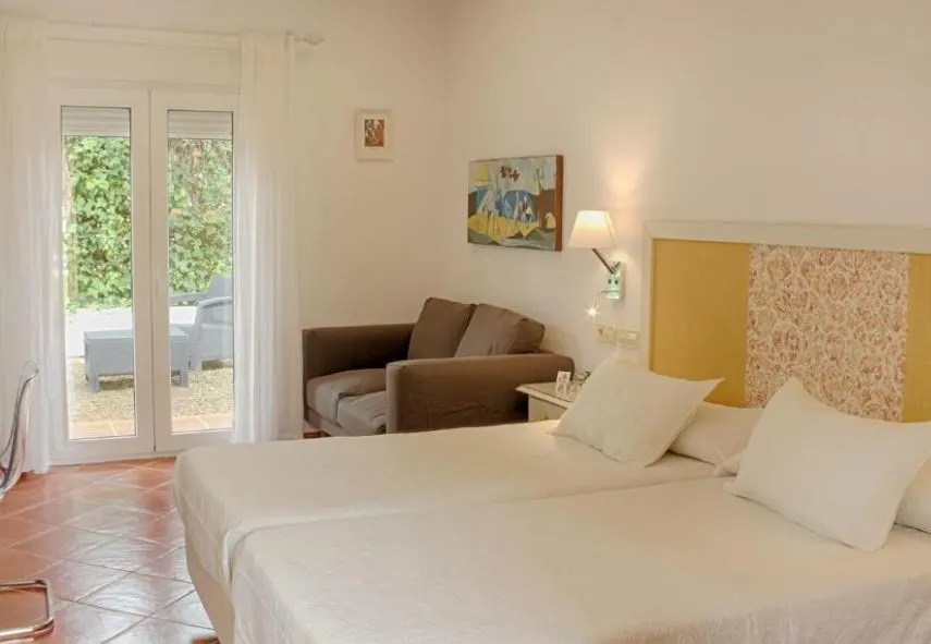 cozy bedroom with bed, sofa, desk and outdoor sitting area at the Hotel Picasso malaga