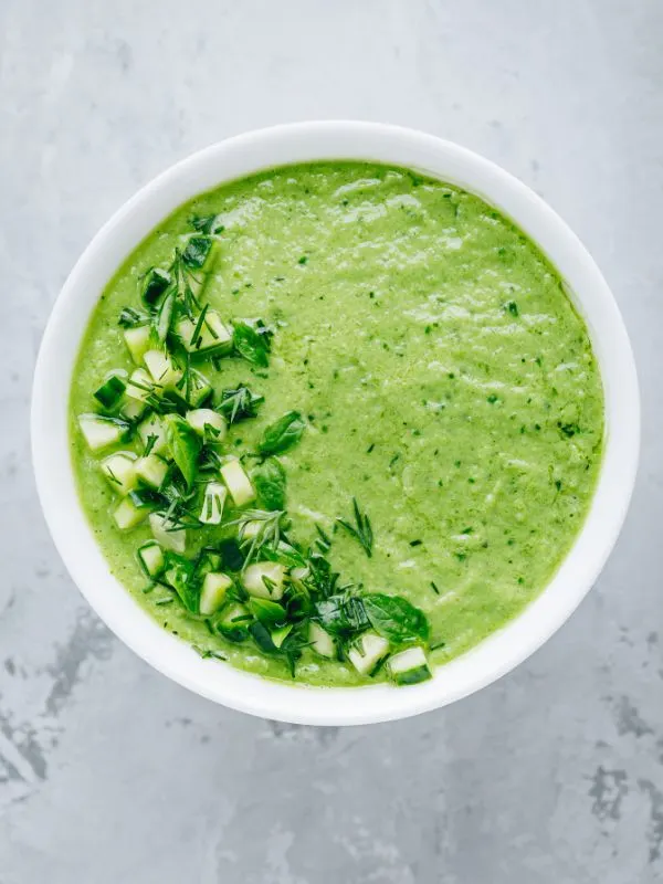 gazpacho verde in a bowl decorated with fresh vegetables - Easy Gazpacho Verde Recipe