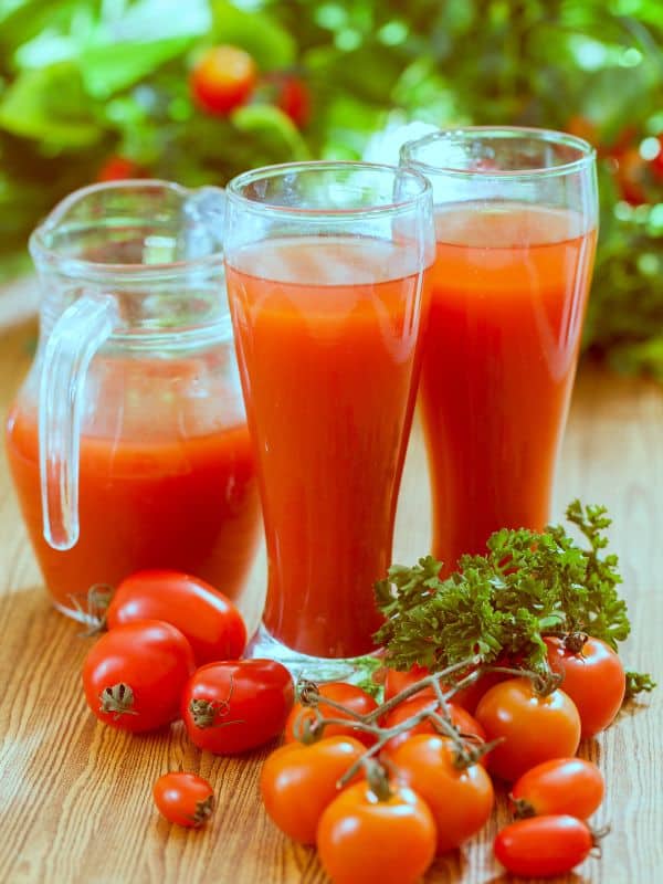 tomato juice in 2 glasses and a jar for the tomato juice gazpacho