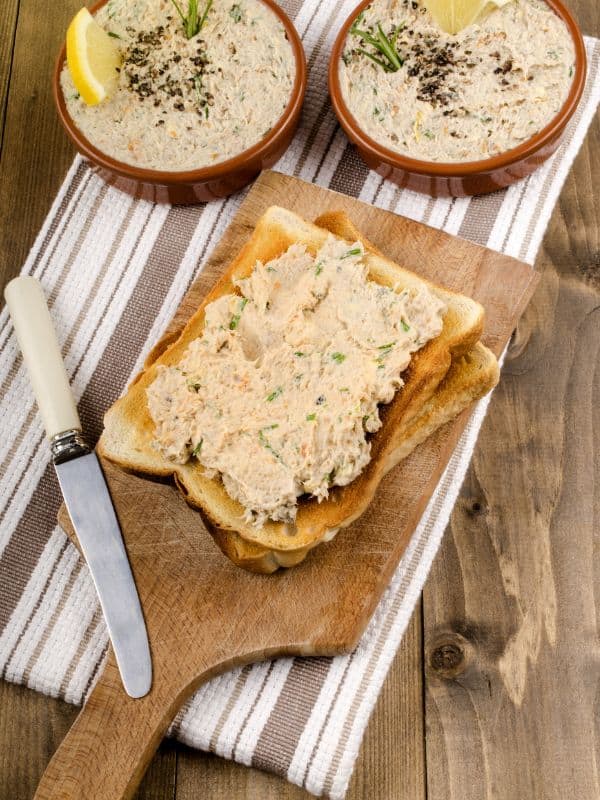 2 bowls of mackerel pate recipe next to a toast with pate on a wooden board.