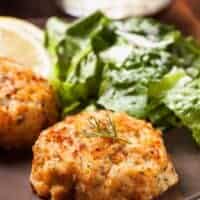 2 mackerel patties on a plate with salad made with the mackerel cake recipe