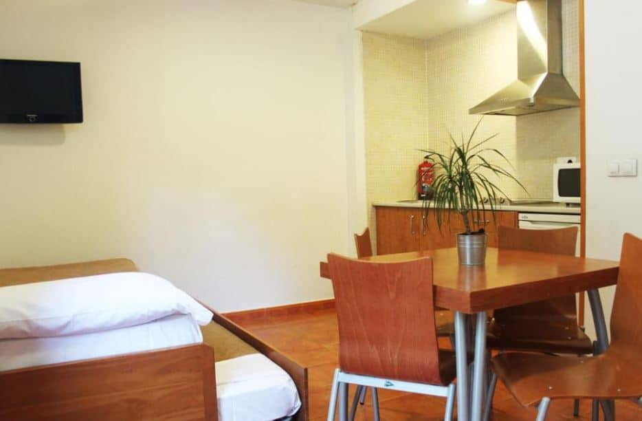 fully equipped apartment with kitchen, table and bed at Apartamentos GHM Gorbea in Sierra Nevada